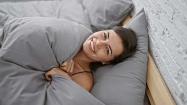 Işıl ışıl, genç İspanyol bir kadın rahat, rahat bir sabah geçiriyor rahat yatağında uzanıyor, güzel döşenmiş odasında, pozitif bir ifadeyle gülümsüyor..