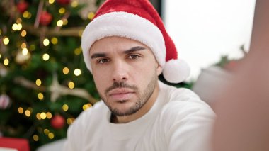 Genç İspanyol adam Noel 'i kutluyor. Evde kamerayla selfie çekiyor.