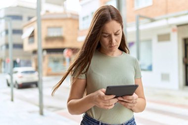 Sokakta dokunmatik yüz ifadesi olan genç ve güzel bir kadın.