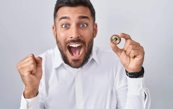 Handsome Hispanic Man Holding Polkadot Cryptocurrency Coin Screaming Proud Celebrating — Stock Photo, Image