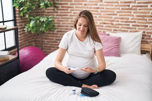 Yatakta Oturan Genç Hamile Kadın Glikoz Ölçümü Yapıyor — Stok fotoğraf