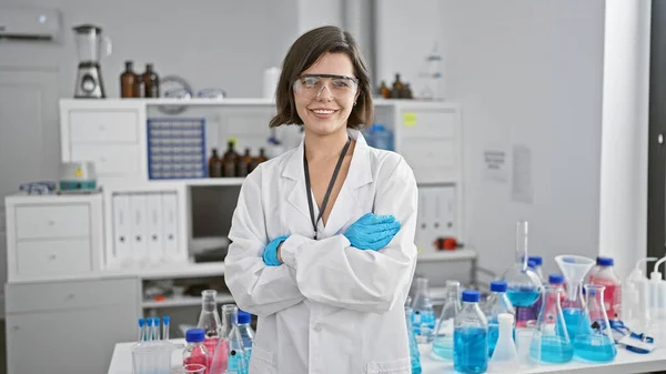 At the research clinic, a confident young scientist stands, arms crossed, in her lab. this hispanic woman, beautiful with a radiant smile, embodies the future of medicine