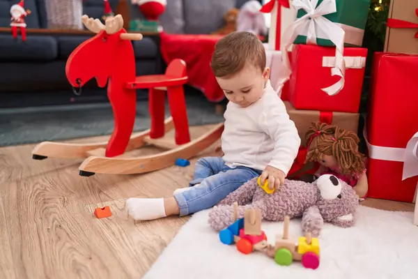 自宅で遊ぶクリスマスプレゼントで床に座っている愛らしい白人赤ちゃん — ストック写真