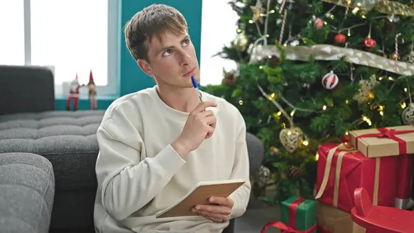Jonge Kaukasische Man Glimlachend Schrijven Notities Vieren Kerst Thuis — Stockfoto