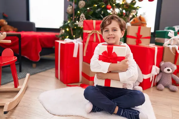 Schattige Spaanse Jongen Knuffelen Kerstcadeau Zitten Vloer Thuis — Stockfoto