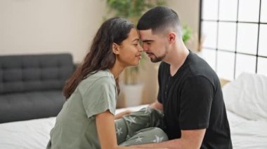 Güzel aşk sabah parlıyor, çift yatak odasında mutlu bir şekilde dinleniyor, evde rahat yastıkların arasında oturuyor.