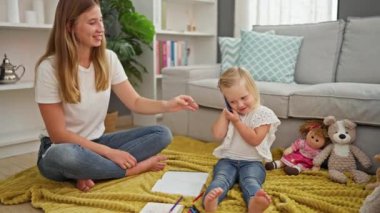 Kafkas anne ve kızının telefonda iç açıcı konuşması oturma odasında otururken, evde oyuncaklarla çevriliyken..