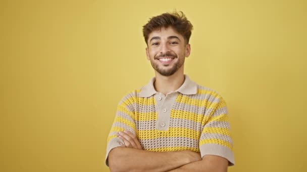 年轻的 微笑的成年人 一个阿拉伯男子的快乐和自信的表情 双手交叉地站在一起 被黄色的背景隔开 — 图库视频影像