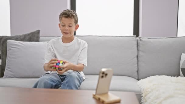 Sevimli Sarışın Çocuk Kanepede Oturuyor Kendinden Emin Bir Şekilde Rubik — Stok video