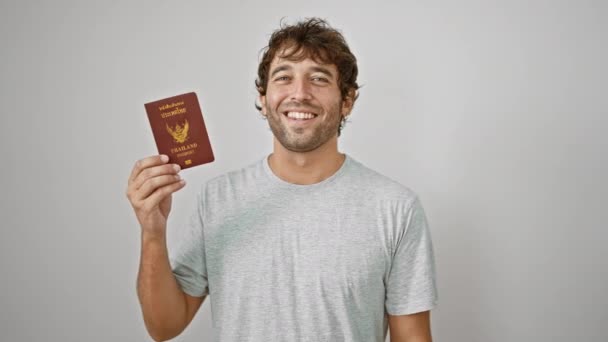 陽気な若いタイ人男性は 自信を持ってパスポートを振り 旅行チェックを通過する準備ができて 孤立した白い背景の上に喜びと幸せを放射します — ストック動画