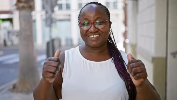 즐겁고 자신감있는 아프리카계 미국인 햇볕이 거리에 엄지손가락을 그녀의 빛나는 — 비디오