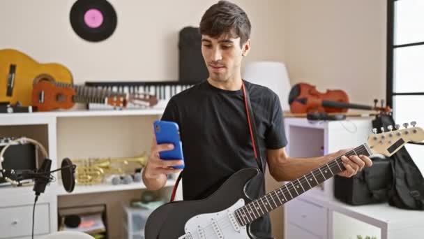 Smiling Young Hispanic Man Rockstar Musician Electrifies Room Making Selfie — Stock Video