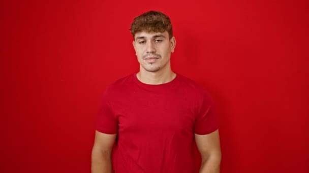 Jonge Knappe Spaanse Man Glimlachend Met Vertrouwen Geïsoleerde Rode Achtergrond — Stockvideo
