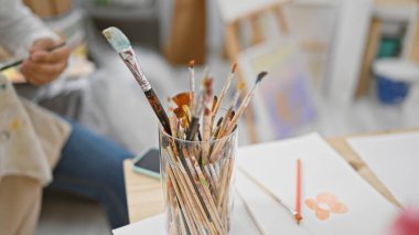 Çekici İspanyol genç adam, gri saçlı sanatçı yaratıcılığını ifade ediyor, kapalı bir sanat stüdyosunda ustaca çizim yapıyor.