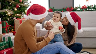 Bir çift ve oğlu balo düzenliyor. Evdeki Noel ağacının yanında oturuyorlar.