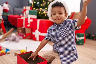 Afrika kökenli Amerikalı çocuk hediyelerini açıyor. Yılbaşı hediyeleriyle evde oturuyor.