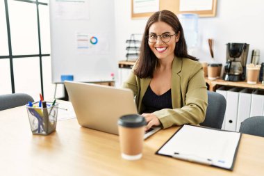 Young beautiful hispanic woman business worker using laptop working at office