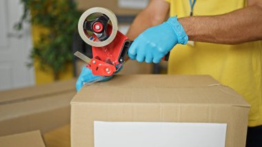 Genç İspanyol gönüllü, hayır kurumuna bağış yapmak için karton kutu paketliyor.