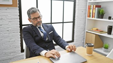 Yakışıklı, beyaz saçlı, kendine güveni tam, rahat bir şekilde ofisinin içinde oturan yakışıklı, başarılı işi hakkında derin düşüncelere dalmış..