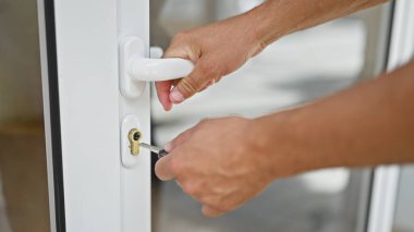 Evdeki anahtarı kullanarak kapıyı kapatan genç bir İspanyol.