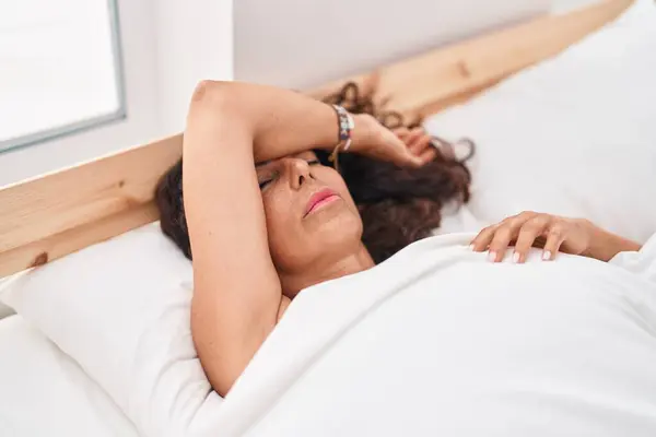 Middle age woman lying on bed sleeping at bedroom