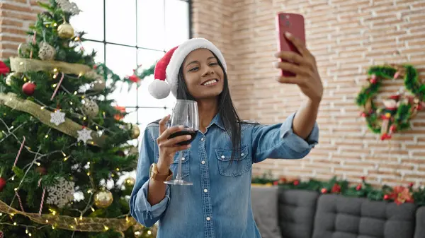 African american woman make selfie by smartphone drinking wine celebrating christmas at home
