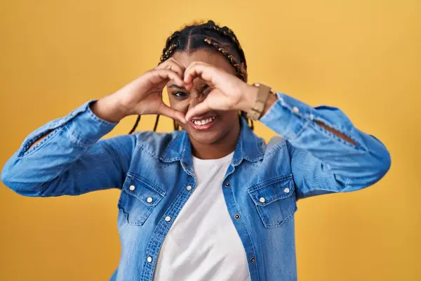 Afroamerikanerin Mit Zöpfen Steht Auf Gelbem Hintergrund Und Macht Herzform — Stockfoto