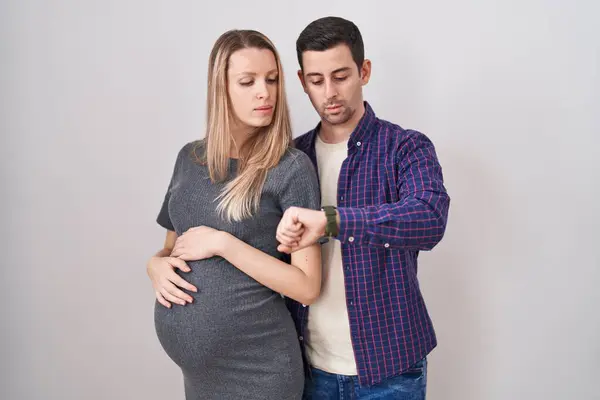 Genç Bir Çift Beyaz Arka Planda Bir Bebek Bekliyor Saati — Stok fotoğraf