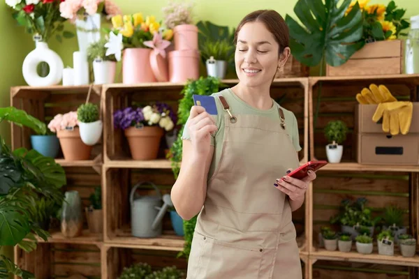 Jovem Linda Florista Usando Smartphone Segurando Cartão Crédito Loja Flores — Fotografia de Stock