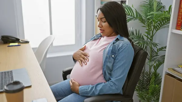 成功的年轻怀孕女商人摸着肚子 坐在办公室桌旁 一边工作一边拥抱母亲 — 图库照片
