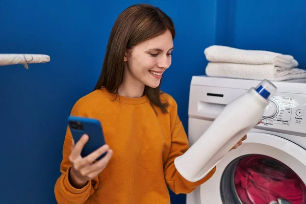 Çamaşır Odasında Elinde Deterjan Şişesi Tutan Genç Sarışın Kadın — Stok fotoğraf