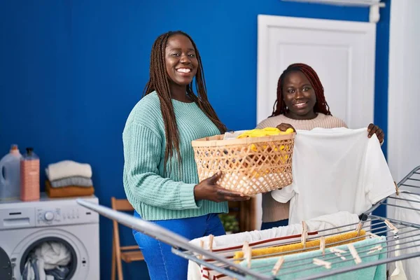 Mujeres Afroamericanas Sonriendo Confiadas Colgando Ropa Tendedero Lavandería —  Fotos de Stock