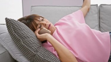 Kanepesinden telefonla konuşan yorgun, genç İspanyol bir kadın esnemiş, kısa saçlı, oturma odasında kaybolmuş gevşemiş ambiyansı.. 