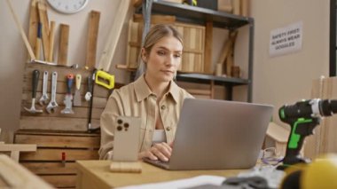 Marangozhanedeki genç sarışın kadın korkuyla ağzını kapatıyor. Dizüstü bilgisayarında bir hata yaptığında şaşırmış yüz ifadesi.