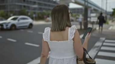 Gözlüklü güzel İspanyol kadın, gelişigüzel yürüyüp gidiyor, telefon elinde Tokyo 'nun modern sokaklarında,.
