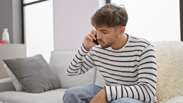 Hombre Árabe Joven Estresado Discutiendo Furiosamente Por Teléfono Sentado Sofá — Vídeos de Stock