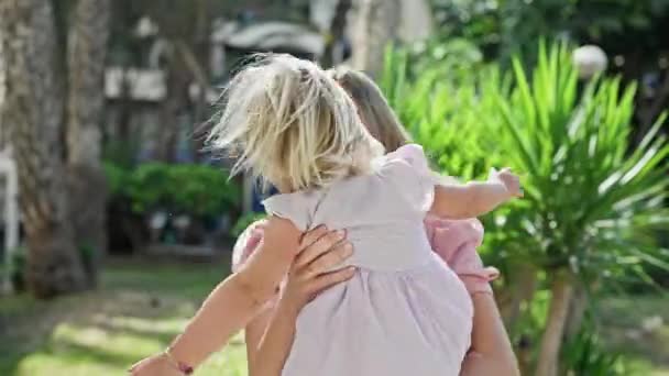 公園で踊る陽気な母親 彼女の笑顔の娘は彼女の腕の中で 日光を浴び 喜びに基づいて — ストック動画