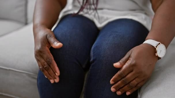 在一个安静的室内下午 非洲裔美国女人坐在舒适的沙发上 双手忍受着腕部疼痛 尽量放松下来 — 图库视频影像