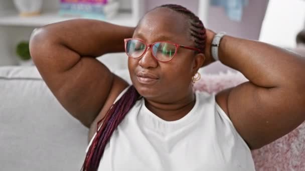 Χαρούμενη Αφροαμερικάνα Αυτοπεποίθηση Χαλαρώνει Στον Καναπέ Στο Σπίτι Χέρια Ακουμπάνε — Αρχείο Βίντεο