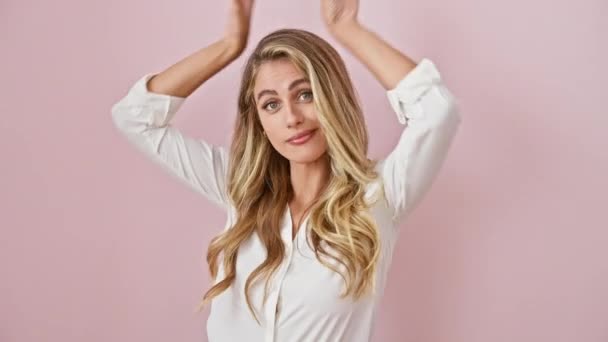Skeptische Blondine Macht Verrückte Osterhasenohren Mit Palmen Über Rosa Hintergrund — Stockvideo