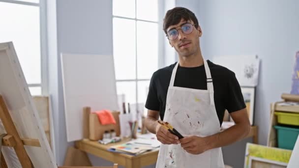 Knappe Jonge Spaanse Kunstenaar Glimlachend Met Gekruiste Armen Zelfverzekerd Staand — Stockvideo