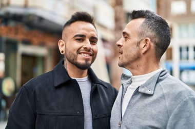 Two men couple smiling confident standing together at street