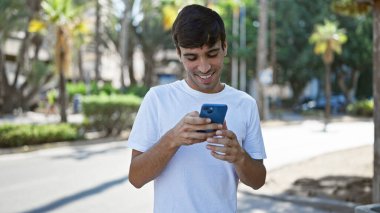 Neşeli genç İspanyol adam gezici teknoloji kullanarak şehrin göbeğinde mesajlaşıyor. Yakışıklı adam gülümsüyor, dijital dünyasında kayboluyor doğanın yeşillikleri arasında..