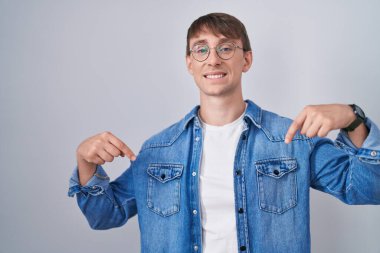 Beyaz, sarışın, gözlüklü, kendine güvenen, gülümseyen, kendini gururlu ve mutlu gösteren bir adam.. 