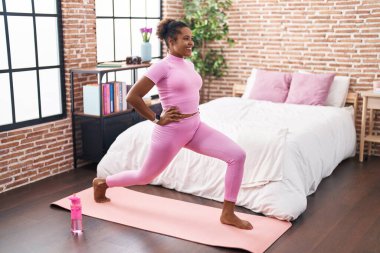 African american woman smiling confident training leg exercise at bedroom