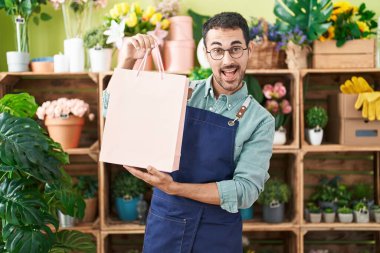 Çiçekçide çalışan yakışıklı, çılgın ve başarıyı kutlayan, gözleri açık, heyecanla haykıran bir İspanyol.. 