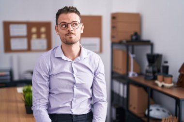 Ofisteki genç İspanyol adam gülümsüyor, yan tarafa bakıyor ve düşünüyor.. 