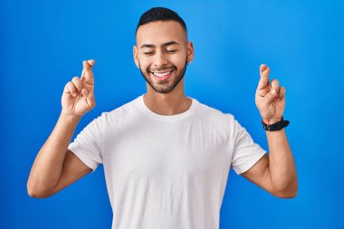 Mavi arka planda dikilen Latin kökenli genç adam umut ve gözlerin kapalı gülümseyerek bana işaret etti. Şans ve batıl inançlar. 