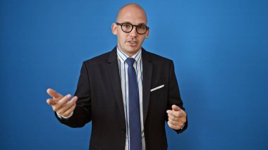 Genç İspanyol iş adamı soyutlanmış mavi arka planda konuşuyor.