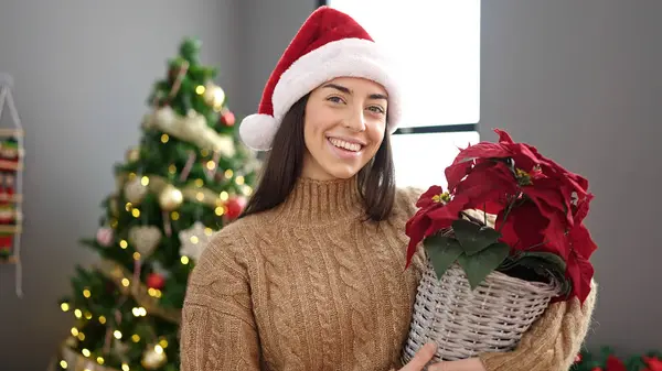 若いです美しいですヒスパニック女性を保持クリスマス植物立って自宅 — ストック写真